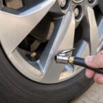 ホイール奥のタイヤバルブに空気入れの口金を近づけている様子