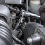 車のエンジン周辺で首振り式のソケット工具を斜めに当てている様子
