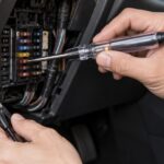 車内のヒューズ周辺をペン型検電テスターで点検している様子