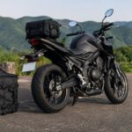 山道で小型バイクと大小のシートバッグを並べたイメージ