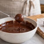 チョコレートフォークで丸いトリュフをコーティングしている様子