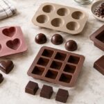 ハート型や半球型など複数のチョコレートモールドを並べた様子