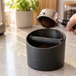 エスプレッソマシン横のノックボックスへコーヒーかすを落とす様子