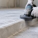 コンクリート床の段差部分を研削工具で削っている様子