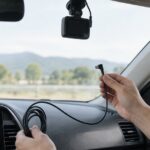 車内でドライブレコーダー用の電源ケーブルを手に持っている様子