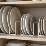 食器棚の中で大きさの異なる皿をラックに立てて収納している様子