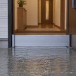 雨水が迫る住宅玄関に止水板を設置した様子