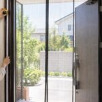 玄関ドアの内側で網戸を付ける枠の高さを測っている様子