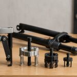 自転車フォークと複数のクラウンレース取り外し工具を作業台に並べた様子