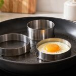 フライパンに大きさの異なる目玉焼きリングを並べた様子