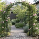 バラとつる植物が絡む金属製ガーデンアーチと庭の通路