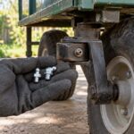 園芸用運搬車の車輪付近で複数のグリスニップルを見比べる様子