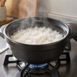 ガスコンロに載せた鍋で白いご飯を炊いている様子