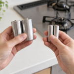 ガスコンロの前で大きさの異なる乾電池を持ち比べている様子