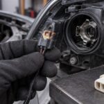 焼けたヘッドライト用カプラーと交換候補を車両前方で見比べる様子