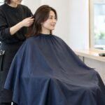 理美容室でカットクロスを着けて施術を受ける人