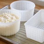 穴あきの丸型と角型で凝乳を水切りしている様子