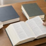複数の無地の辞典を机上で見比べている様子