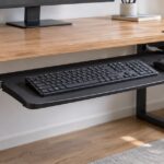 木製デスクの下にキーボードとマウス用トレーを取り付けた様子