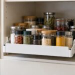 キャビネットから引き出したトレーに複数のスパイス瓶を収納している様子