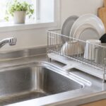 シンク横の水切りラックに食器や調理器具を置いたキッチンの様子