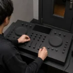 4本のチャンネルフェーダーを備えたDJ機器を操作する様子