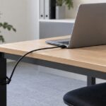 ノートPCをワイヤーで机の脚に固定している様子