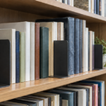 高さの異なる本を金属製ブックエンドで支えた図書館の書架