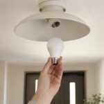横向きの電球ソケットと手に持ったLED電球を見比べる様子