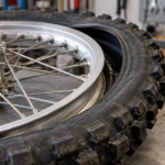 オフロードバイクのスポークホイールとリムロックを作業台に置いた様子