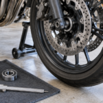 バイクの前輪と汎用ベアリング、ノギスを整備場所に並べた様子