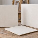画室の机に通常枠、厚枠、薄型の白いキャンバスを並べた様子