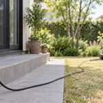 屋外コンセントから庭の作業場所へ延びる電源コード
