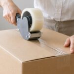 段ボール箱に透明な梱包テープを貼っている様子