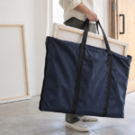 絵画用キャンバスを紺色のバッグに入れて運ぶ様子
