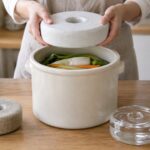 漬物容器に合う大きさの重石を選んでいる様子