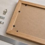 木製額縁の背面と複数形状の吊り金具を並べた様子