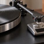 レコードプレーヤーの針をデジタル針圧計に載せて測定している様子