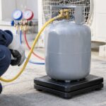 冷媒ボンベを電子スケールに載せて空調機器を整備している様子