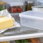 冷蔵庫内にバターと透明な保存ケースを並べたイメージ