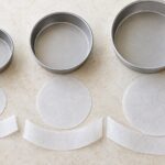 大きさの異なる丸型ケーキ型と底面・側面用の敷紙を並べた様子