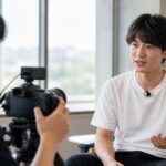 カメラで人物へのインタビュー音声を収録している様子