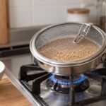 ガスコンロで網ぶた付きの煎り器を使ってごまを煎る様子