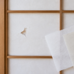 白い障子の小さな破れと色合いの異なる補修用和紙