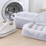 洗濯機の前にスニーカーとクッション入りの靴用洗濯ネットを並べた様子