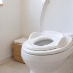 大人用便座に白い幼児用補助便座を載せたトイレの様子