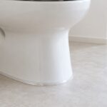 白い便器の根元と床のすき間を透明テープで覆ったイメージ