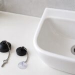大きさと鎖の固定方法が異なるゴム栓を手洗器の横に並べた写真