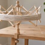 木製の傘型かせくり器に毛糸のかせを掛けた作業風景