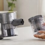掃除機本体の横で交換用ダストケースを手に持っている様子